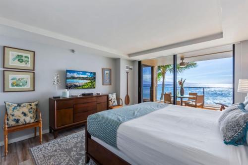 Un dormitorio con una cama y vista al mar. en Incredible Views Mahana 219, en Kahana