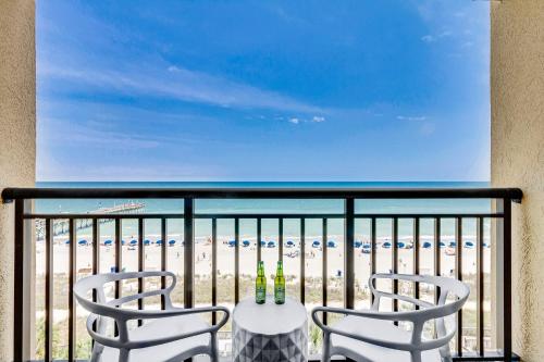 Playa Poesia By Casanita - Oceanfront Lux Studio في ميرتل بيتش: كرسيين وطاولة على شرفة مع الشاطئ