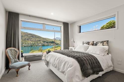 una camera da letto con una grande finestra e un letto e una sedia di The Middleton Room a Queenstown