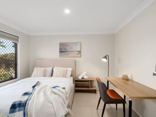ein Schlafzimmer mit einem Bett, einem Schreibtisch und einem Tisch in der Unterkunft Sunnybank Hills Retreat 6 Beds Near Market Square in Brisbane