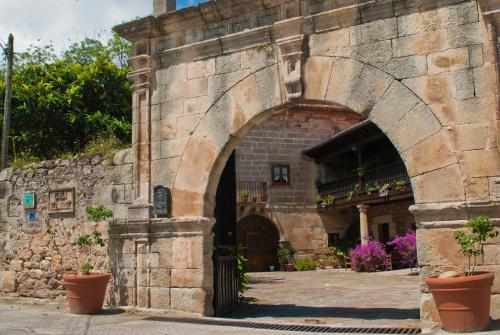 an archway in a stone building with potted plants at Casa Velarde in Torrelavega