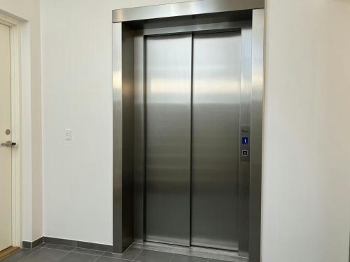 un ascensor en un edificio con una puerta de metal en Spacious Apartment for 3, en Odense
