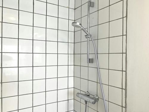 a bathroom with a shower with white tiled walls at Spacious Apartment for 5 in Odense