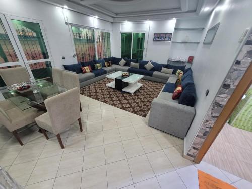a living room with a couch and a table at Villa Magnifique duplex à Martil in Martil