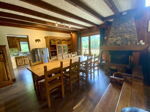 une salle à manger avec une table et des chaises et une cheminée dans l'établissement Chalet Des Sangliers, à Séez