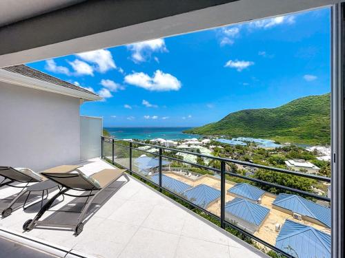 a balcony with chairs and a view of the ocean at Koala1 Elegant 1BR Duplex, Anse Marcel, Sea View in Anse Marcel 