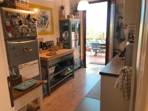 a kitchen with a refrigerator and a table in it at Tramonto Mediterraneo casa con piscina in Castiglioncello