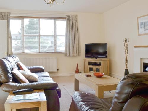 Una sala de estar con un sofá y una mesa de café. en School Knott Cott, en Windermere