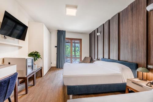 a hotel room with a bed and a tv at Hotel Baia Imperiale in Campo nell'Elba