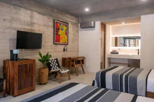 a hotel room with two beds and a flat screen tv at Jiloo- Beautiful Oasis in Punta Zicatela 7 in Brisas de Zicatela