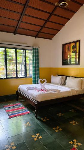a bedroom with a bed with a heart on it at Marutham Village Resort in Mahabalipuram