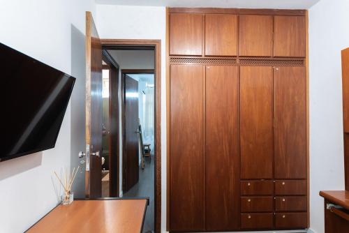 a bathroom with wooden cabinets and a mirror at Apto c boa localizacao prox centro pet friendly in Jundiaí
