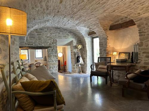 un salon avec un canapé et un mur en pierre dans l'établissement Maison de village avec piscine, à Saint-Étienne-de-Lolm