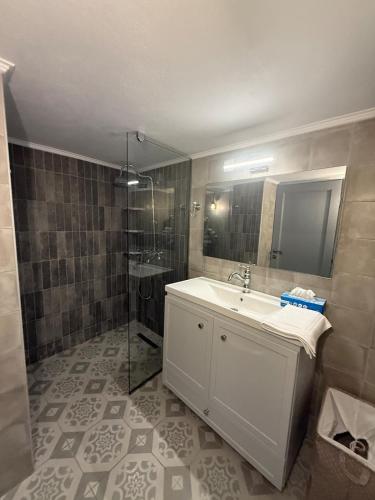 a bathroom with a white sink and a shower at Gorgeous restored house at Platanos square in Lésvos