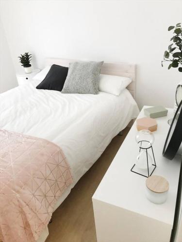 a white bedroom with a bed and a white desk at Suite Estébanes in Zaragoza