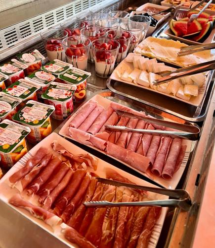 a buffet filled with hot dogs and other foods at Hotel L'Escapade in Le Lavandou