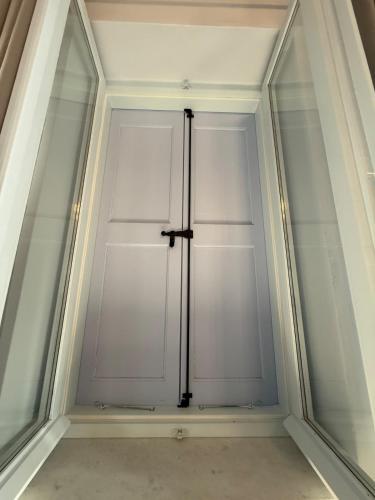 a closet with white doors in a room at Gorgeous restored house at Platanos square in Lésvos