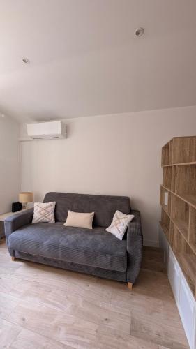 - un salon avec un canapé gris dans l'établissement Appartement studio, à Nice