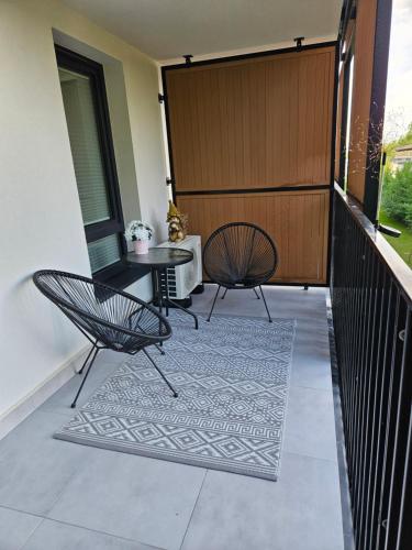 a balcony with two chairs and a table at Biała Perła - Apartament Augustów in Augustów