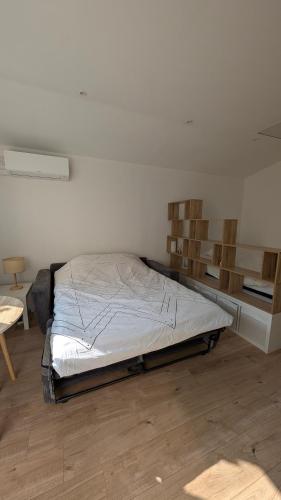 Ce lit se trouve dans un dortoir doté d'étagères en bois. dans l'établissement Appartement studio, à Nice