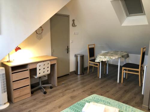 Cette chambre comprend un bureau, une table et des chaises. dans l'établissement Nid douillet Lorientais, à Lorient