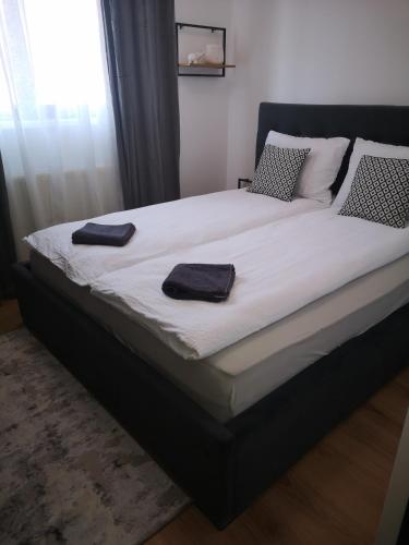 a large bed with two towels on top of it at Chic Apartments - City Center - Free Wifi AC in Carei