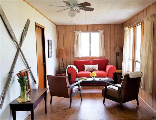 un salon avec un canapé rouge et une table dans l'établissement Comfy Cottage in Georgian Bay - Rockwood #9, à Dillon