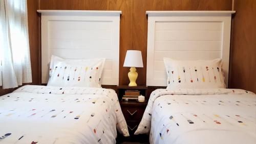 - 2 lits avec des draps blancs et une lampe dans une chambre dans l'établissement Comfy Cottage in Georgian Bay - Rockwood #9, à Dillon