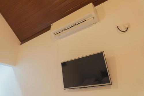 een kamer met een tv en airconditioning aan de muur bij Lakeshore Resort in Anuradhapura