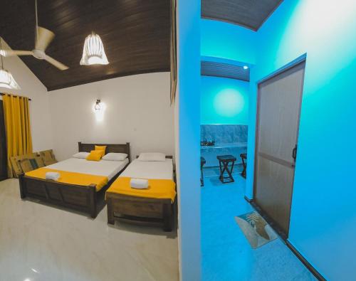 a room with two beds and a tv in it at Lakeshore Resort in Anuradhapura