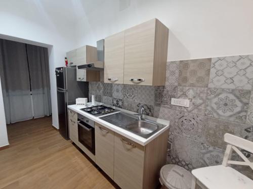 a kitchen with a sink and a stove and refrigerator at Calì eventi room in Torre del Greco