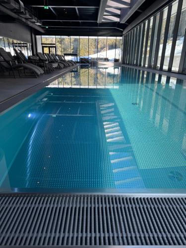 a large swimming pool with blue water in a building at Hotel Pestera Wellness & Spa in Sinaia