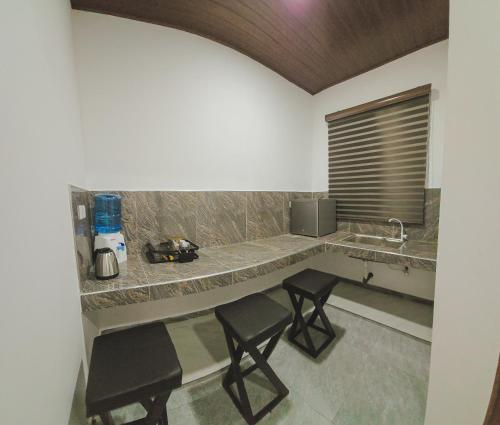 een keuken met 2 stoelen en een aanrecht met een wastafel bij Lakeshore Resort in Anuradhapura