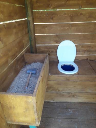 a bathroom with a toilet in a wooden stall at glampling namiot przy podeście in Leszczawka