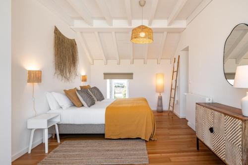 a white bedroom with a bed and a couch at Sea'Ya Thoughtful Stays - Villa Juso in Aldeia de Juso