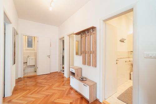 a hallway with white walls and wood floors and a bathroom at Spinut Urban Retreat in Split