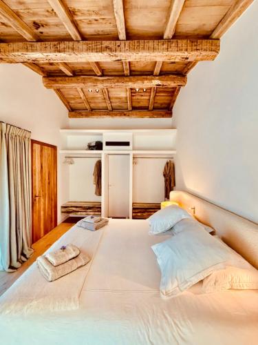 un grand lit dans une chambre avec des plafonds en bois dans l'établissement Villa Mamma, à Zonza