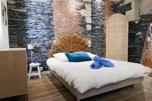 une chambre avec un grand lit avec un mur de briques dans l'établissement Appartement charme de l'ancien - Centre ville Angers- 2 personnes, à Angers