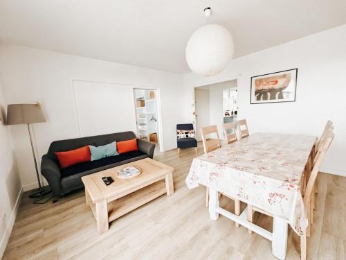 un salon avec une table et un canapé dans l'établissement La belle chanteraine 80 m2 vue Basilique, à Reims