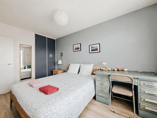 - une chambre avec un lit et un bureau avec un sac rouge dans l'établissement La belle chanteraine 80 m2 vue Basilique, à Reims