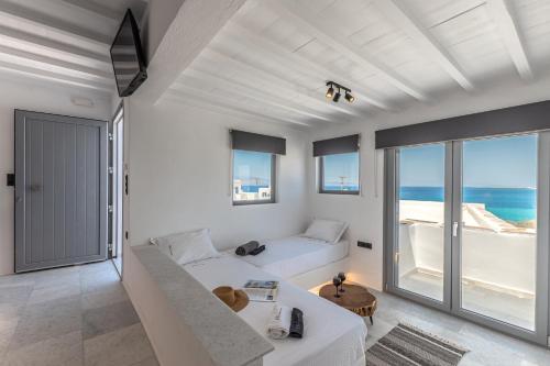 a white living room with a view of the ocean at FK Luxury Suites - Orkos Beach in Mikri Vigla