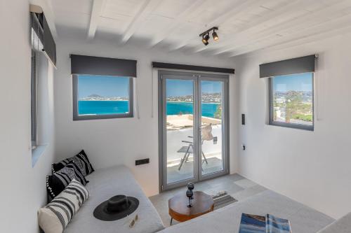 a white living room with a couch and windows at FK Luxury Suites - Orkos Beach in Mikri Vigla