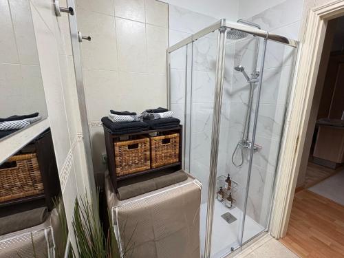 a bathroom with a walk in shower with baskets at Apartamento La Marquesa Beach in Puertito de Güímar