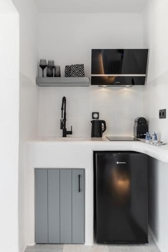 a kitchen with a sink and a microwave at FK Luxury Suites - Orkos Beach in Mikri Vigla