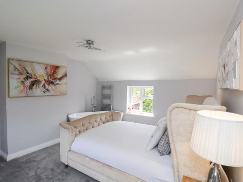 a white bedroom with a bed and a window at Manor Cottage in Harpham