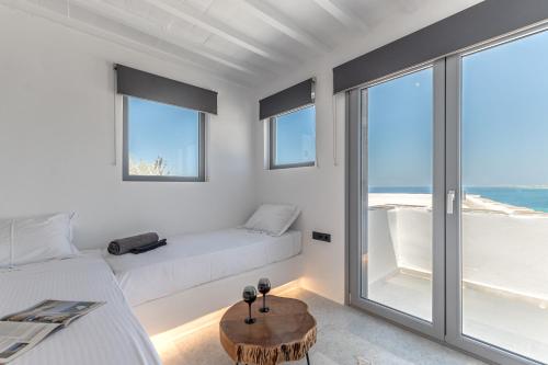 a white room with two beds and a table at FK Luxury Suites - Orkos Beach in Mikri Vigla