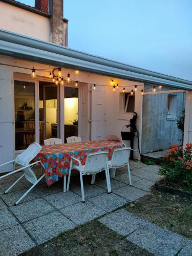 une table et des chaises assises à l'extérieur d'une maison dans l'établissement Cozy and authentic house, à L'Aiguillon-la-Presqu'île
