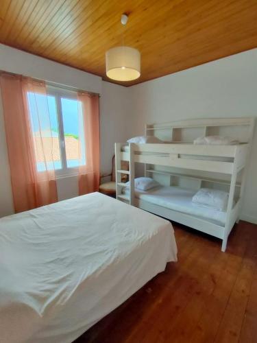 une chambre avec deux lits superposés et une fenêtre dans l'établissement Cozy and authentic house, à L'Aiguillon-la-Presqu'île