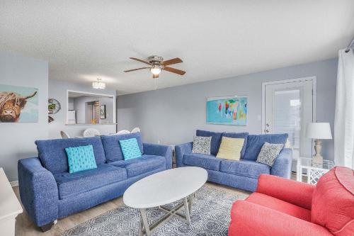 a living room with two blue couches and a table at Sea Oats 102C- Beach view Pool 25 steps to beach in Gulf Shores