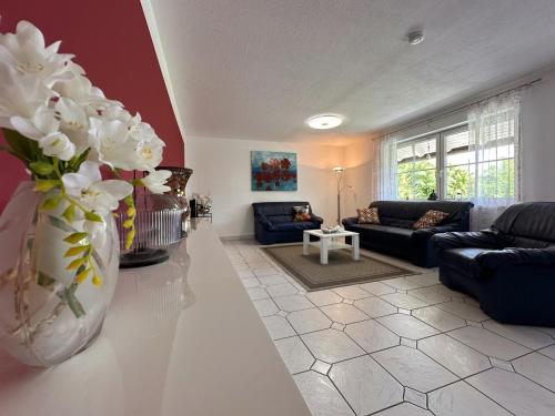 a living room with a vase with white flowers in it at Zur Gradlhöhe in Dietersdorf